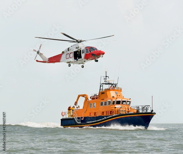 Fototapeta Orange sea rescue boat with rescue helicopter