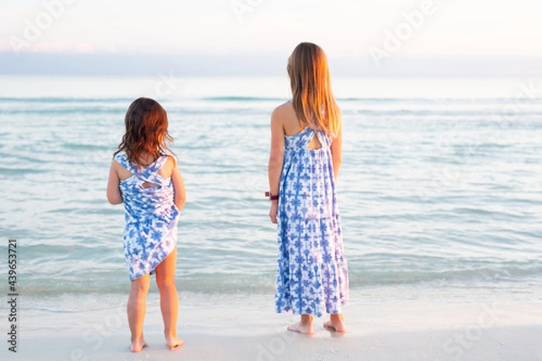 Fototapeta Sisters in Matching Dresses on Beach