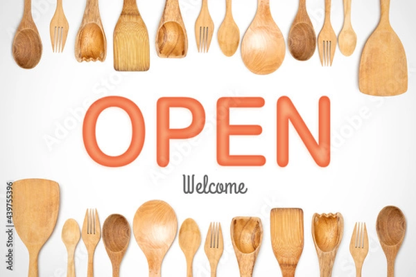 Fototapeta Open welcome with wooden kitchen accessories frame isolated white background. suitable for restaurant decoration. 3d typography image. set of wooden spoons