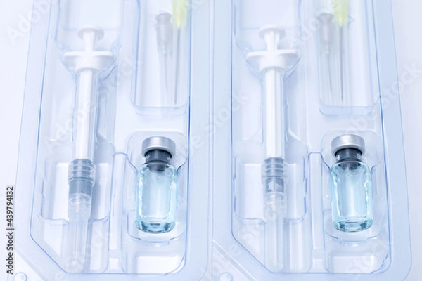 Obraz Covid-19, flu, coronavirus liquid vaccine vial bottle and syringe set in plastic package container preparing for injection on white background. Vaccination for fight Covid-19 virus concept.