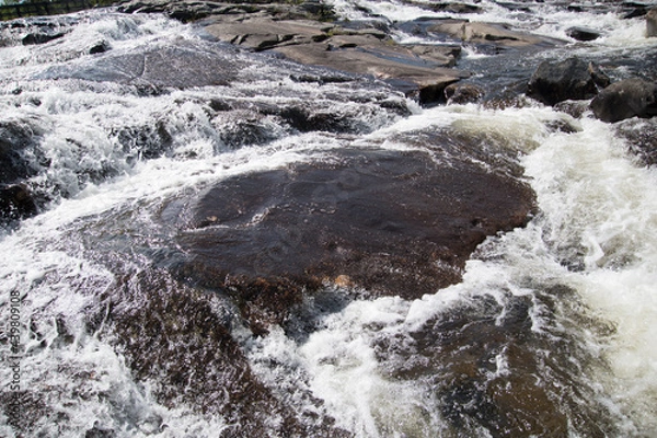 Fototapeta Water flow in a river on a mountain rocks. 