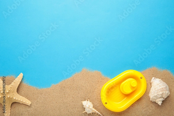 Fototapeta Summer beach toys with accessories on blue background with copy space. Summer frame