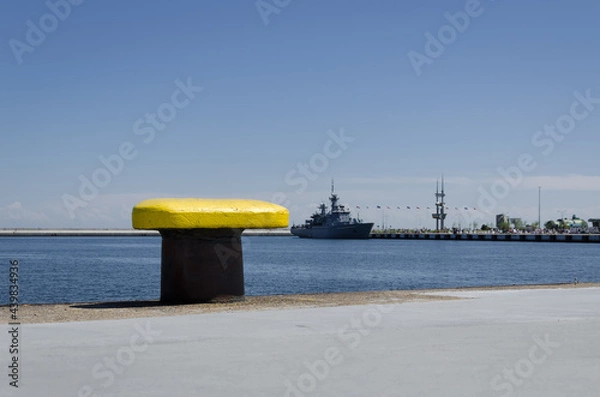 Fototapeta YELLOW BITT - Seaport wharf with warship in the background 
