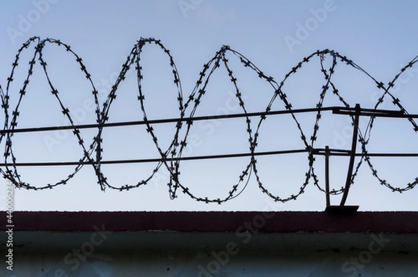 Obraz Fence and barbed wire against the sky
