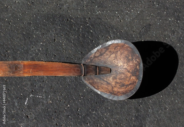 Fototapeta Coconut shell spoon from Indonesia on black background. often used so that it seems classic.