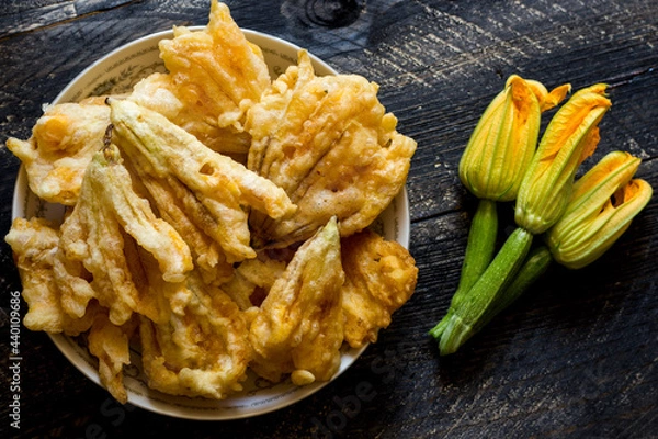 Obraz Fried zucchini flowers in batter on wooden background