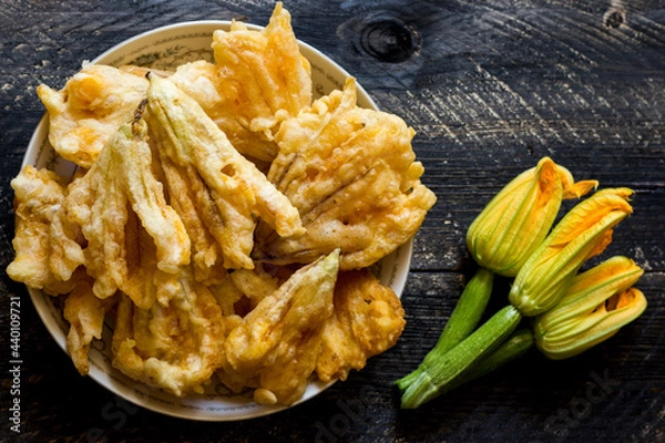 Obraz Fried zucchini flowers in batter on wooden background