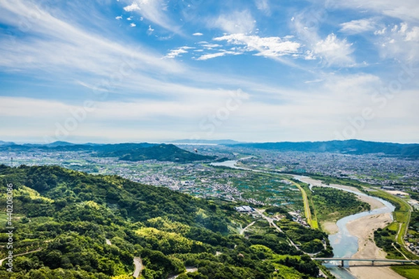 Obraz 梅雨晴れの中、紀の川上空を飛ぶパラグライダーから和歌山市街と和歌山湾を望む