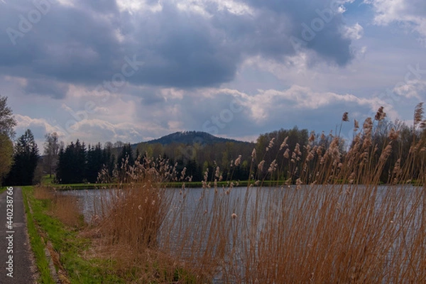 Fototapeta View of the pond in a small village, with a beautiful view of the clouds, a beautiful water level. In the distance a hill called Wolf Mountain.