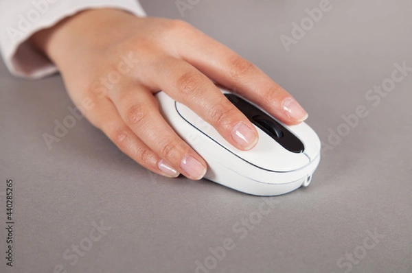 Obraz Woman's hand with computer mouse on table.