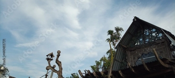 Fototapeta bird house on old wooden tree on cloudy blue sky