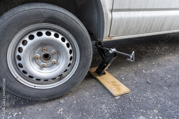 Fototapeta A jack stands up a car.