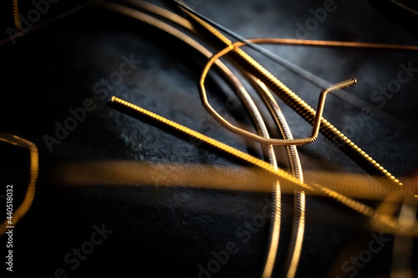 Fototapeta Macro Closeup of Cut End of Bronze Acoustic Guitar String Laying on Used Strings
