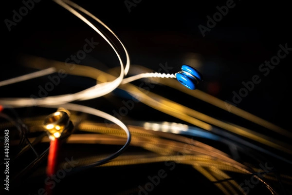 Fototapeta Macro Closeup of Blue Ball End of Bronze Acoustic Guitar String in Front of Group of Loose Used Strings