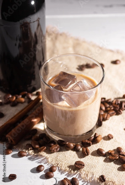 Obraz A glass of Irish cream coffee liqueur with ice and ice. Coffee beans, black bottle.