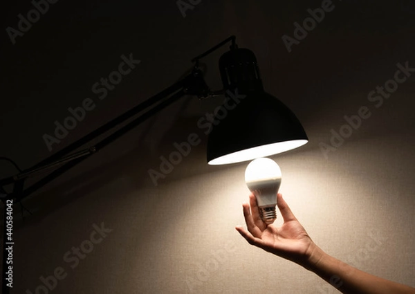 Obraz man is changing the reading lamp