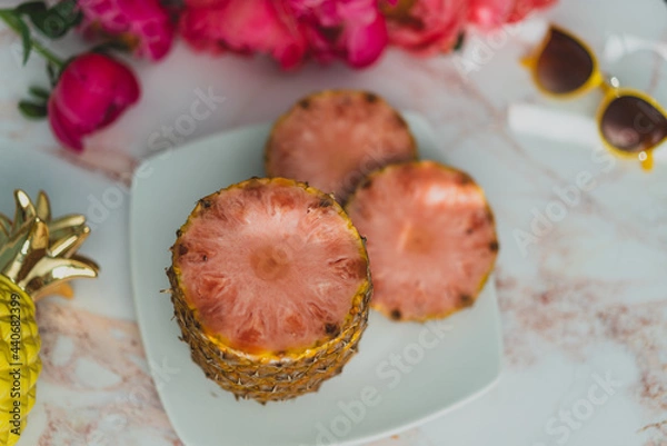 Obraz slices of pink pineapple on a plate with flowers