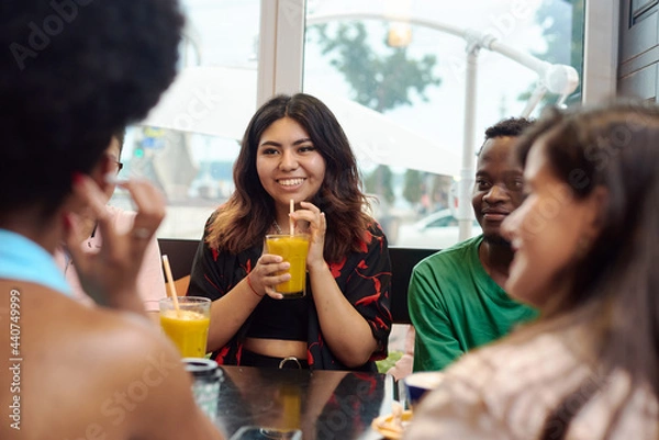 Fototapeta Lifestyle and friendship concepts with real people models. Multinational friends chatting in a cafe. The end of the pandemic.