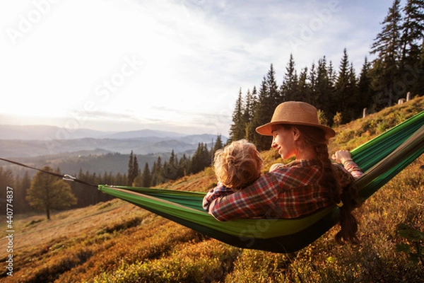 Fototapeta Boy with mom resting in a hammock in the mountains at sunset