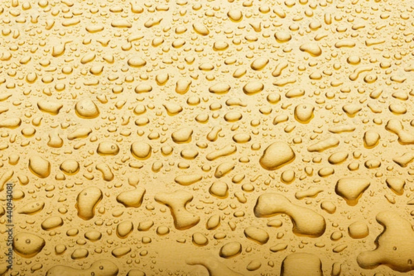 Fototapeta Drops on a gold background. A spray of moisturizing spray from above