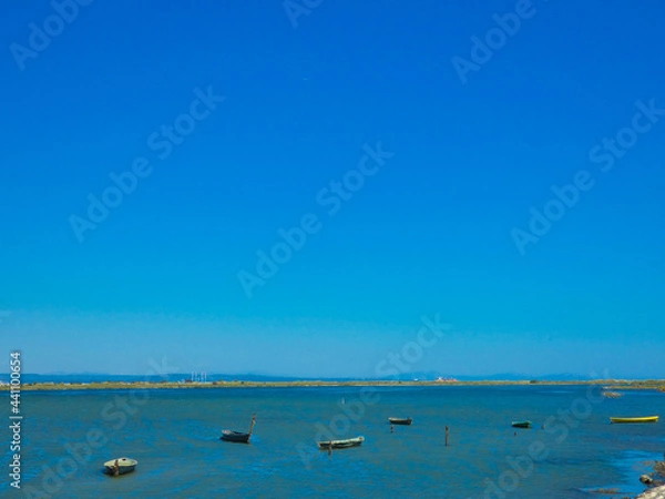 Fototapeta Boats on a small part of the Mediterranean sea protected from the waves by a tongue of land towards Port-Saint- Louis-du-Rhône in Provence in France