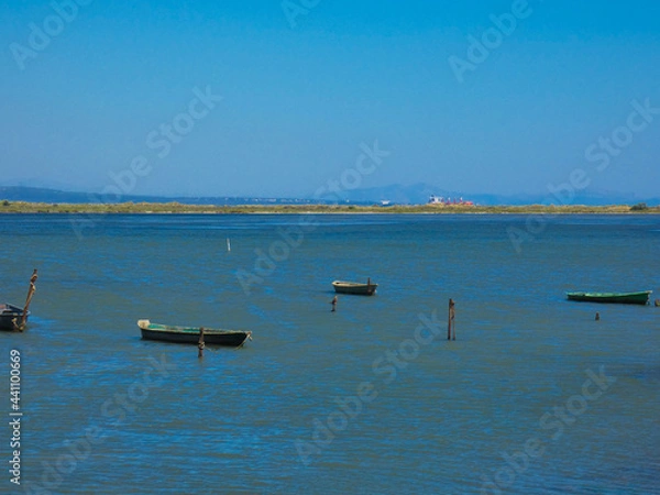 Fototapeta Boats on a small part of the Mediterranean sea protected from the waves by a tongue of land towards Port-Saint- Louis-du-Rhône in Provence in France