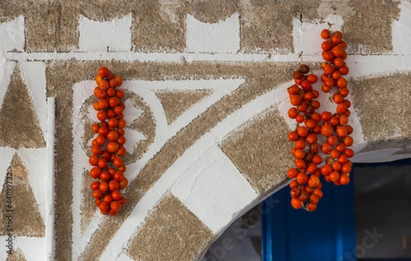 Fototapeta Cherry tomatoes hanging for drying on the typical decorated walls of Pyrgi, a village in the interior of the Greek island of Chios in the north Aegean
