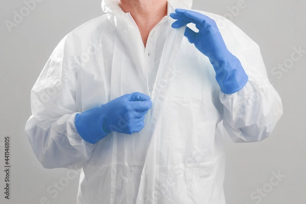 Obraz Close up shot the men in protective hazmat suit pull the zipper out after finish work at the hospital. macro shot men's hands unzips the PPE hazmat suit