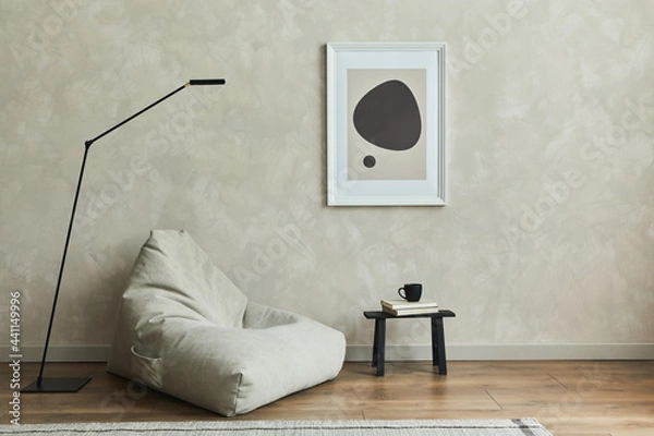 Fototapeta Stylish composition of minimalistic living room interior with mock up poster frame, grey pouf, black tiny coffee table and elegant personal accessories.  Template.