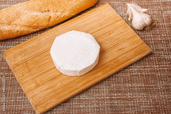 Fototapeta DIY baked cheese camembert instruction step by step. step 1 unpacking camembert.camembert in white paper packaging.cheese with white mold.moldy cheese
