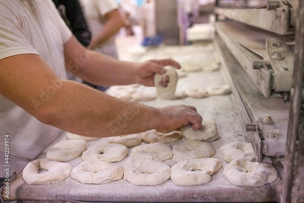 Obraz Baker makes bread and buns for baking it