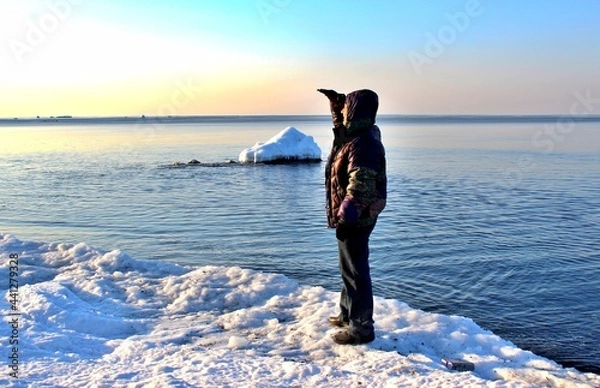 Fototapeta A man standing on an ice floe in the sea and looking into the distance