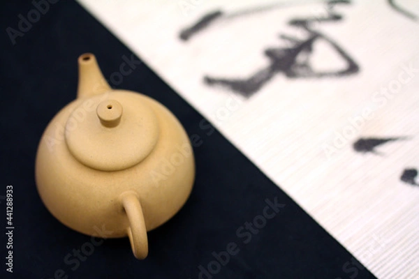 Fototapeta On the black and white contrasting base map, a simple earthenware teapot is placed, full of the natural and comfortable tea culture and Zen style of the East