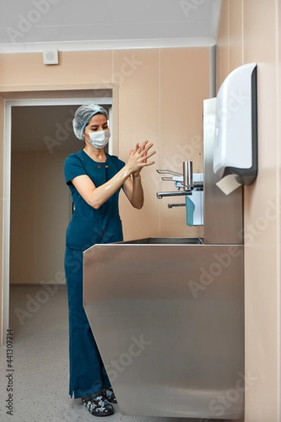 Obraz woman surgeon, washes her hands in the preoperative unit, the surgeon disinfects his hands before the operation.