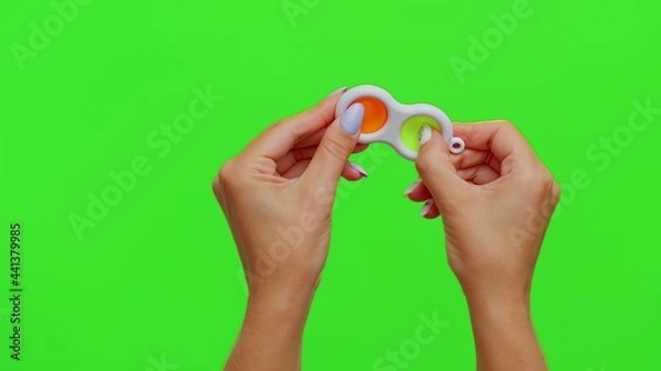 Fototapeta Hands holding silicone bubbles sensory toy simple dimple isolated on chroma key background. Playing push pop it popular educational children game. Trend 2021. Advertising, copy-space. Stress relief
