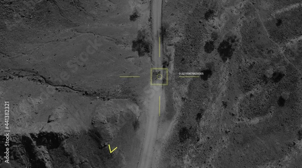 Fototapeta Aerial view of a military drone takes aim at a tank and shoots at it