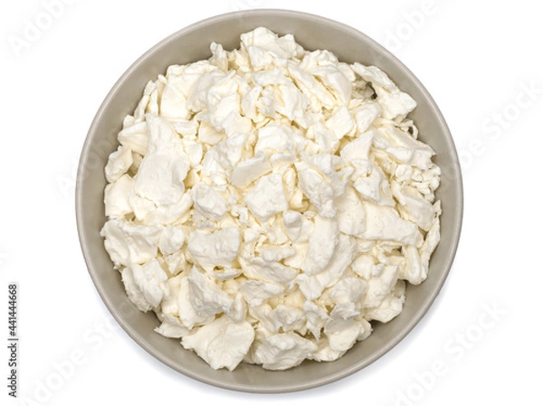 Obraz Cottage cheese in a plate. Fresh cottage cheese on a white background. Homemade curd in minimalism style. Top view.