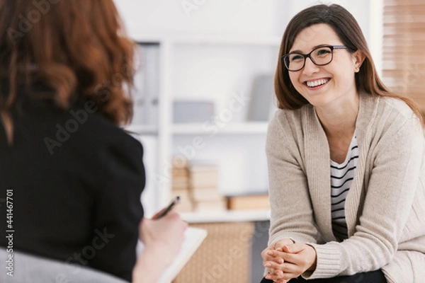 Obraz Happy woman during successful psychotherapy with counselor at clinic