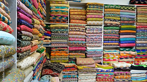 Obraz Traditional oriental multicolored clothes stacked in store. Dubai market. Global village pavilion. Selective focus.  Small depth.