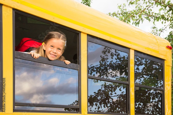 Obraz Little Schoolgirl looking through a Schoolbus Window