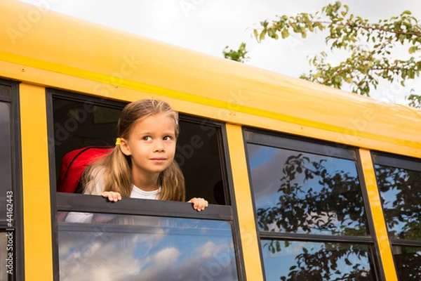 Obraz Little Schoolgirl looking through a Schoolbus Window