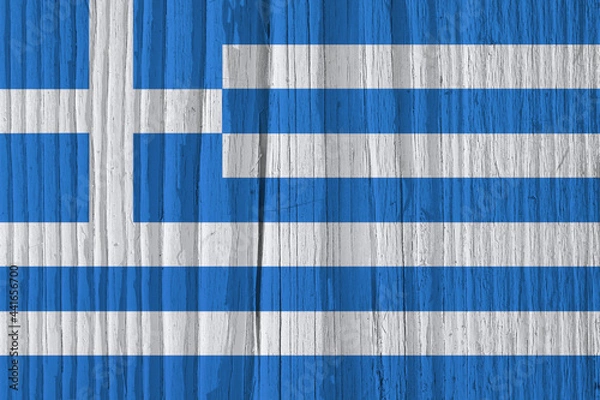 Fototapeta The flag of Greece on dry wooden surface, cracked with age. It seems to flutter in the wind. Background, wallpaper or backdrop with Greek national symbol. Old wood. Hard sunlight with shadows