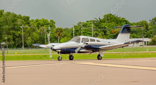 Fototapeta Two engine plane taking off right before a storm hits 