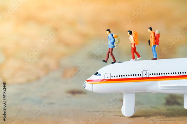 Obraz Miniature people: A traveler mini figures with backpack standing on Global World map balloon. Success Business Due around the world and Traveling agency concepts.