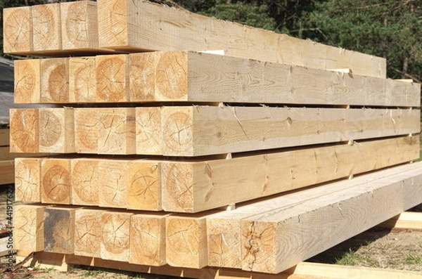 Fototapeta the beams are stacked. sawing logs into boards. construction of a house from a bar.
