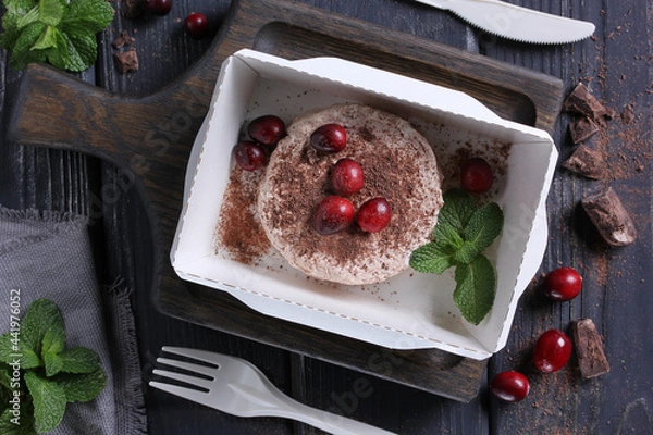 Fototapeta Healthy food. Breakfast for delivery. Cottage cheese, curd with fresh berries,lingonberry, chocolate and mint in a lunch box on a wooden table. Rustic. Background image, copy space