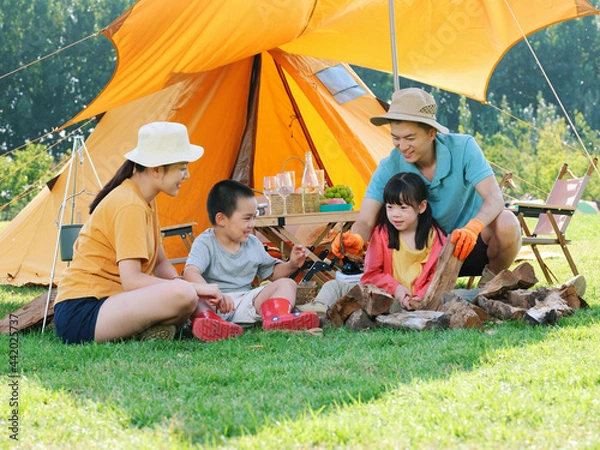 Obraz A Happy family of four camping outdoors