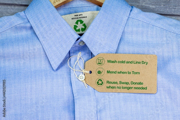 Obraz Made with recycled materials shirt with sustainable fashion care label, fashion wash cold, line dry, mend and repair, reuse, swap or donate with icons.