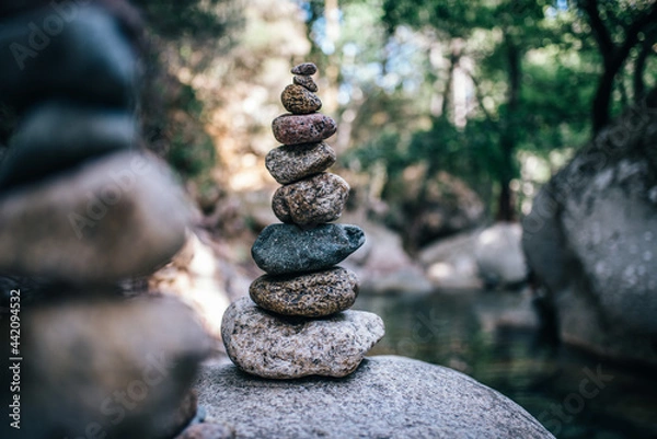 Fototapeta Pyramid of stones in front of a river