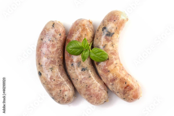 Fototapeta Raw or cooked homemade breakfast sausages decorated with basil leaves, isolated on a white background